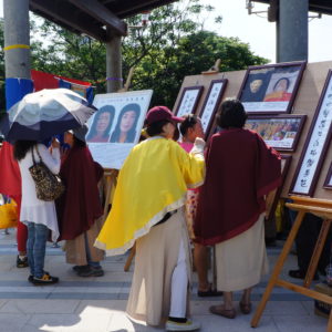 在八里放生法會現場，向當地的遊客講述「南無第三世多杰羌佛返老回春照」，及「因海公聖尊圓寂後以肉身大神變」所創下的佛史新聖蹟