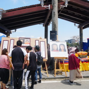 在八里放生法會現場，向當地的遊客講述「南無第三世多杰羌佛返老回春照」，及「因海公聖尊圓寂後以肉身大神變」所創下的佛史新聖蹟