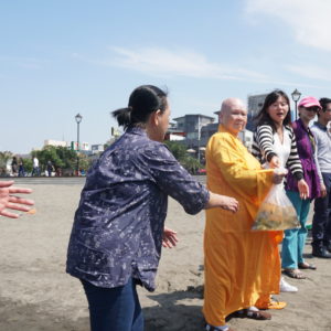 上千信眾及義工參與放流法會將袋中的魚以符合漁業署標準放流方式，使二十多萬尾烏魚，黃鰭鯛魚苗自由地由袋中游出返回淡水河