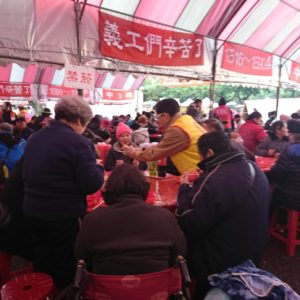 義工師兄姊逐桌發送四臂觀音唐卡，一句聖號，一句祝福