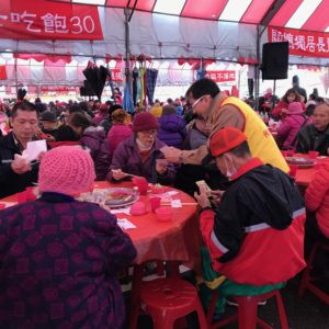 義工師兄姊逐桌發送四臂觀音唐卡，一句聖號，一句祝福
