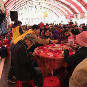 義工師兄姊逐桌發送四臂觀音唐卡，一句聖號，一句祝福