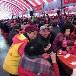 義工師兄姊逐桌發送四臂觀音唐卡，一句聖號，一句祝福