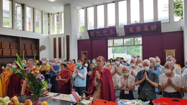 本會執行長索南平措仁波且(中)與板橋榮民之家主任(穿藍背心者)帶領信眾恭誦佛說阿彌陀經