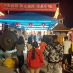 周末晚上湧入大批人潮參拜佛殿，敲響祈福鑼