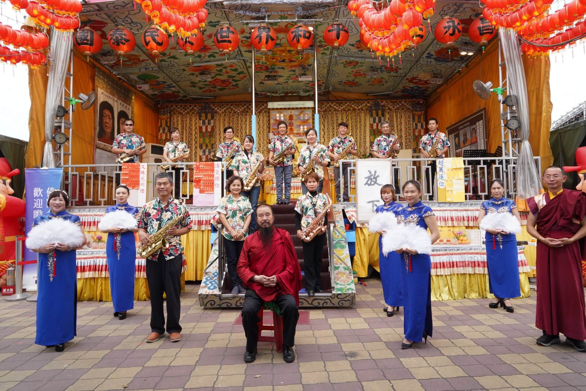 行動佛殿125站屏東里港，本會指導上師恆性嘉措仁波且(中坐者)與表演團體合影，一人一封福慧發財金祝福大眾元宵節快樂