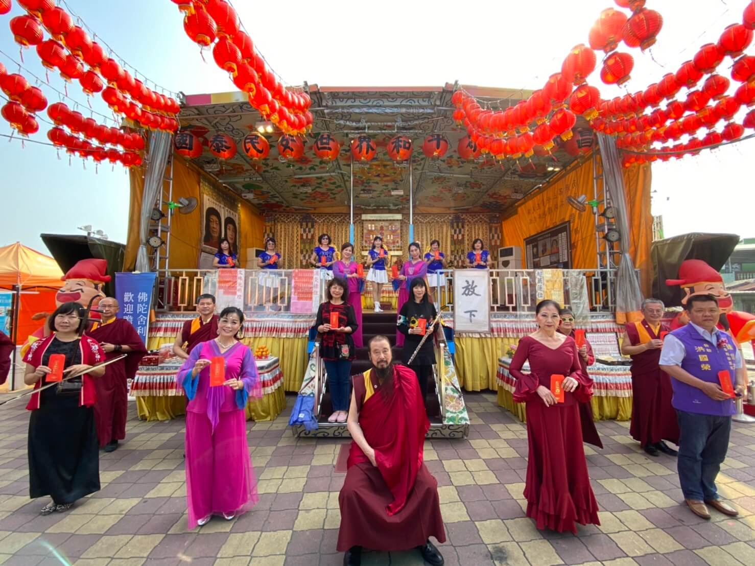 行動佛殿125站屏東里港，本會指導上師恆性嘉措仁波且(中坐者)與表演團體合影，一人一封福慧發財金祝福大眾元宵節快樂