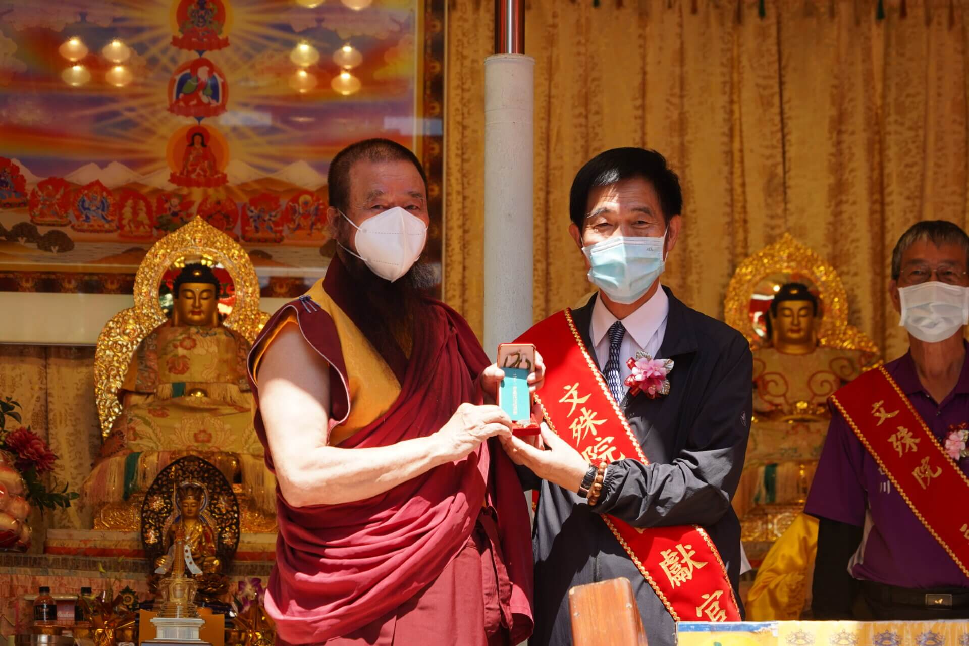 世界佛教正心會啟建地藏法會，本會指導上師恆性嘉措仁波且(左)致贈綠度母墜子給榮家家主任張長林(右)