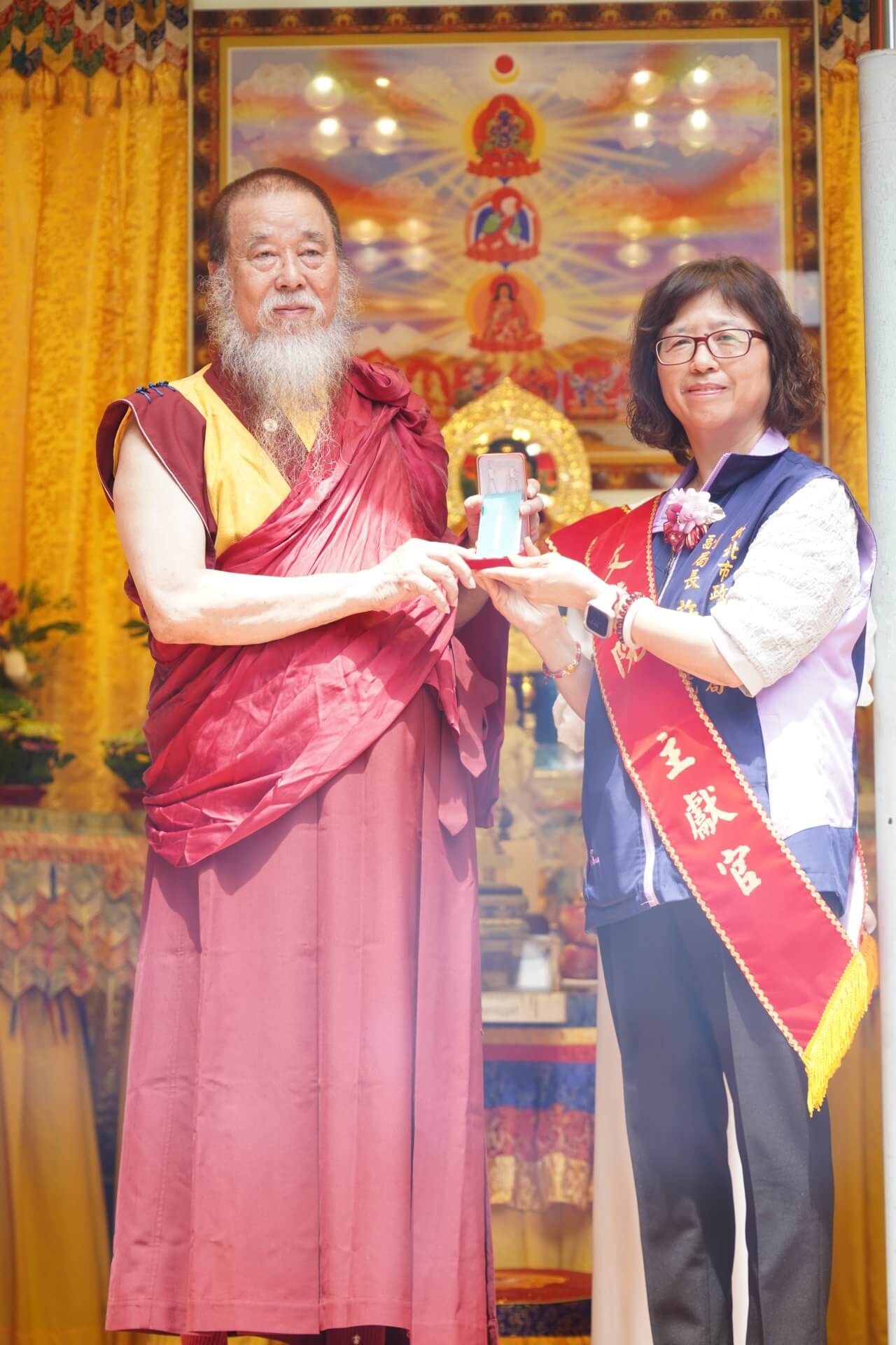 世界佛教正心會舉辦浴佛法會,本會指導上師恆性嘉措仁波且(左)致贈綠度母墜子予新北市政府社會局許秀能副局長(右)