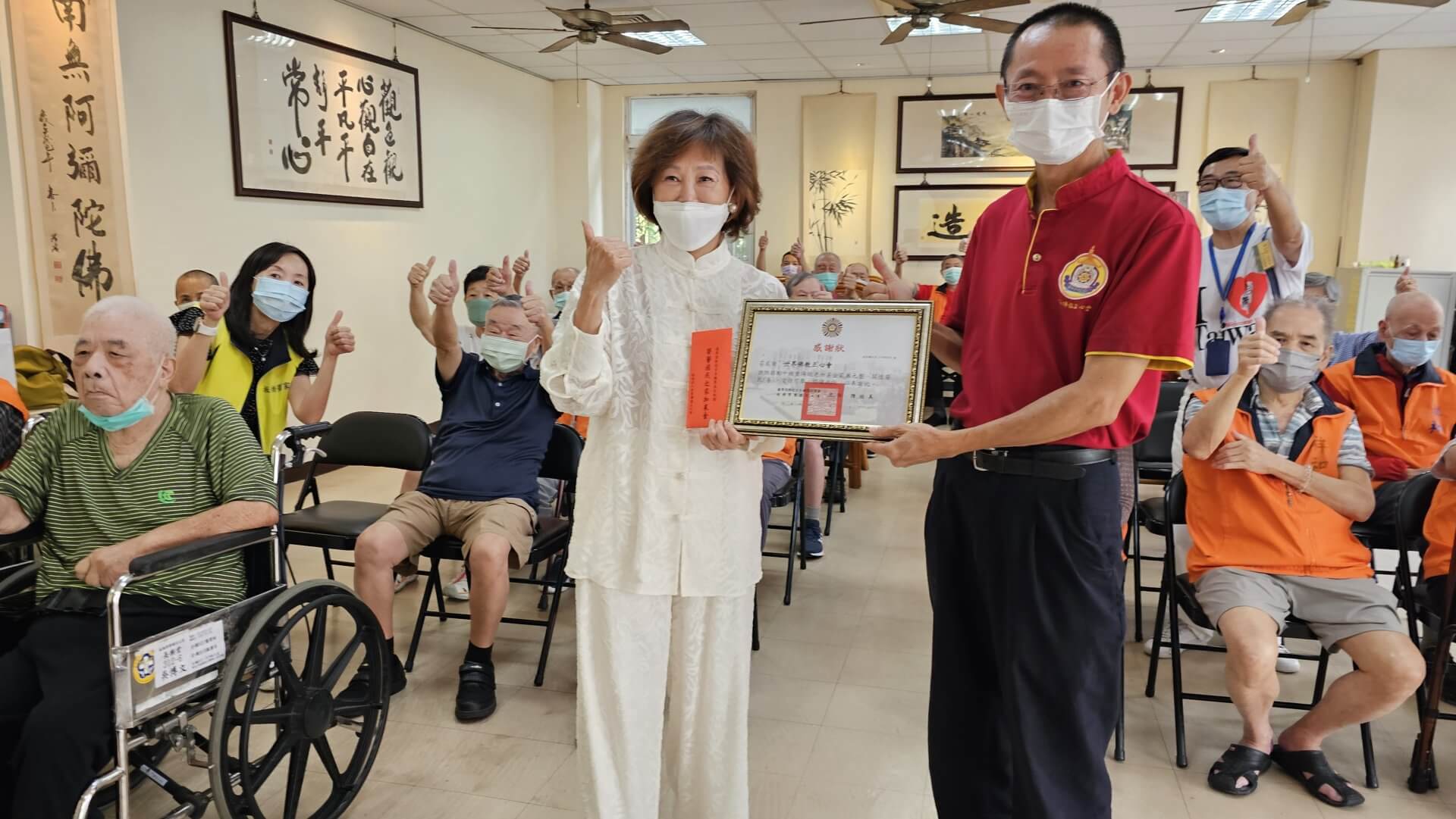 世界佛教正心會致贈板橋榮家加菜金,家主任陳桂美女士(左)代表領受