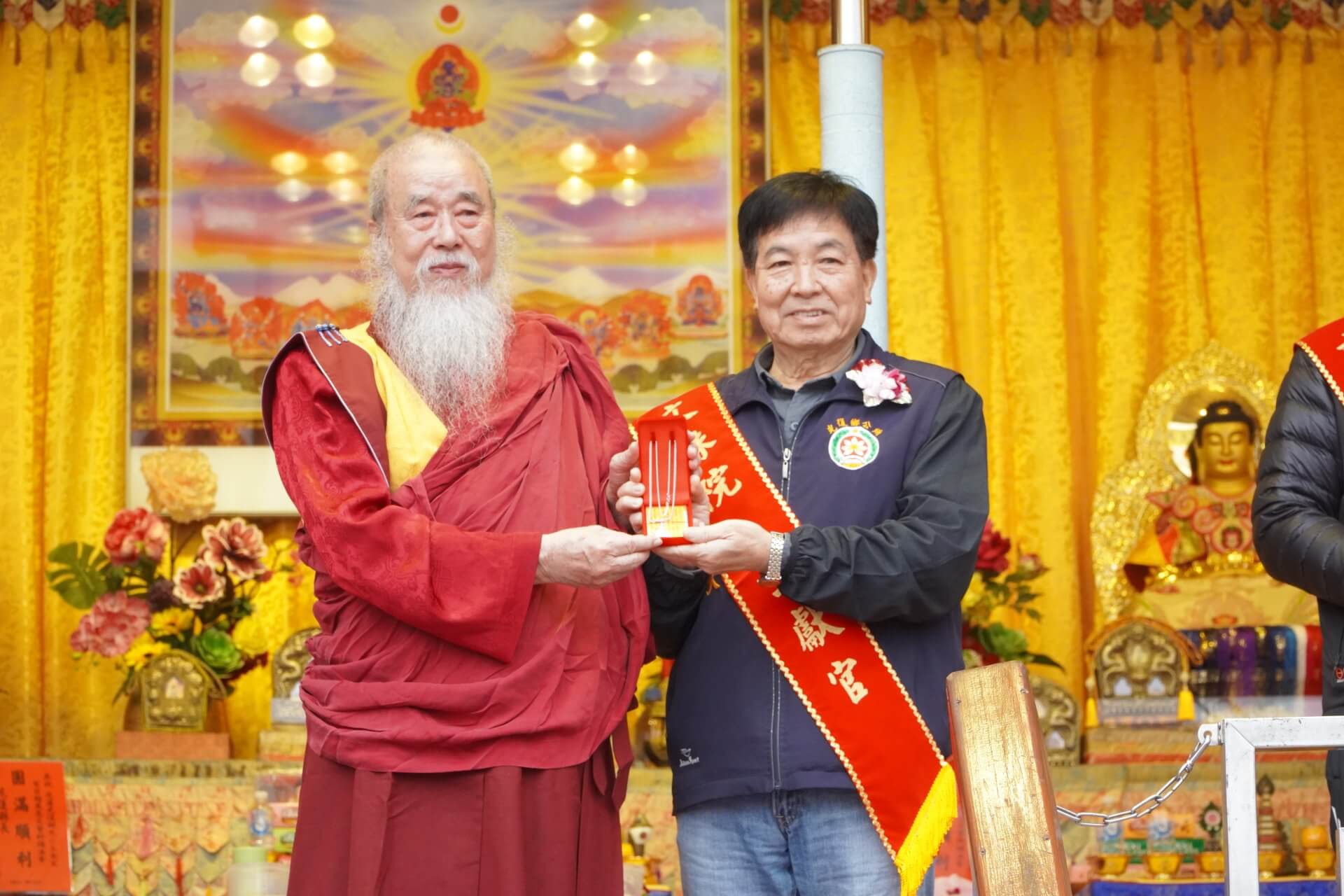 世界佛教正心會於元旦到花蓮光復舉辦百日超薦法會，本會指導金剛上師恆性嘉措仁波且(左)致贈文殊菩薩墜子給光復鄉鄉長林清水(右)