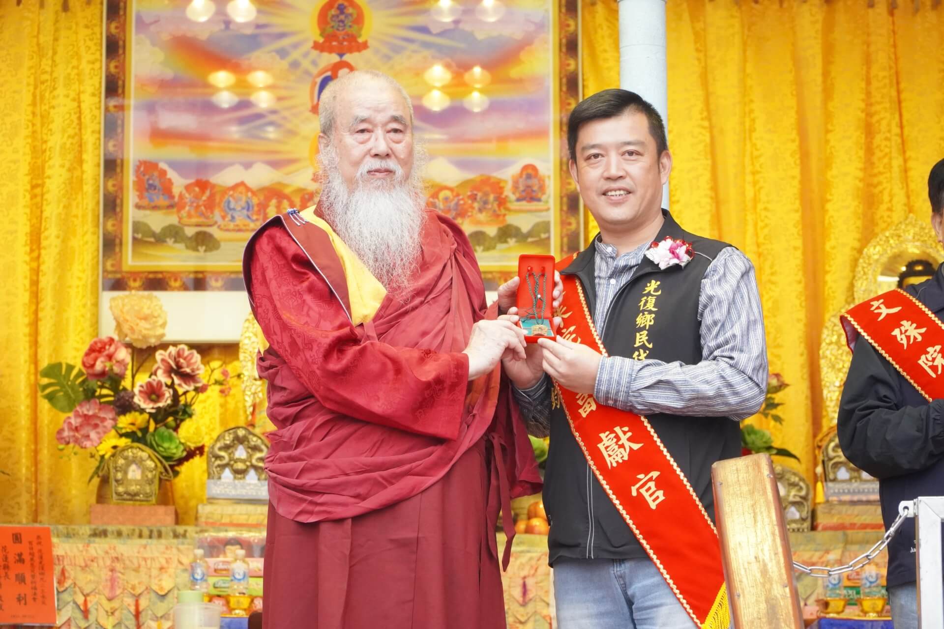 世界佛教正心會於元旦到花蓮光復舉辦百日超薦法會，本會指導金剛上師恆性嘉措仁波且(左)致贈綠度母墜子給光復鄉鄉民代表會主席廖翊鈞(右)