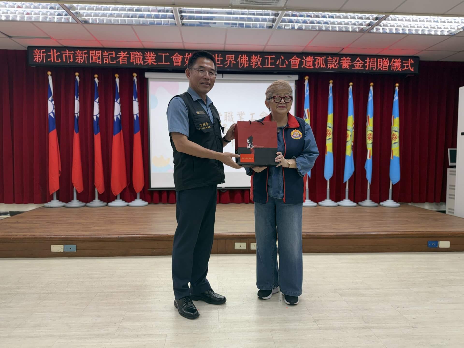 本會執行長陳和慧代表捐贈台北市榮民服務處遺孤認養慰問金，黃信仁處長回贈陳和慧執行長茶葉