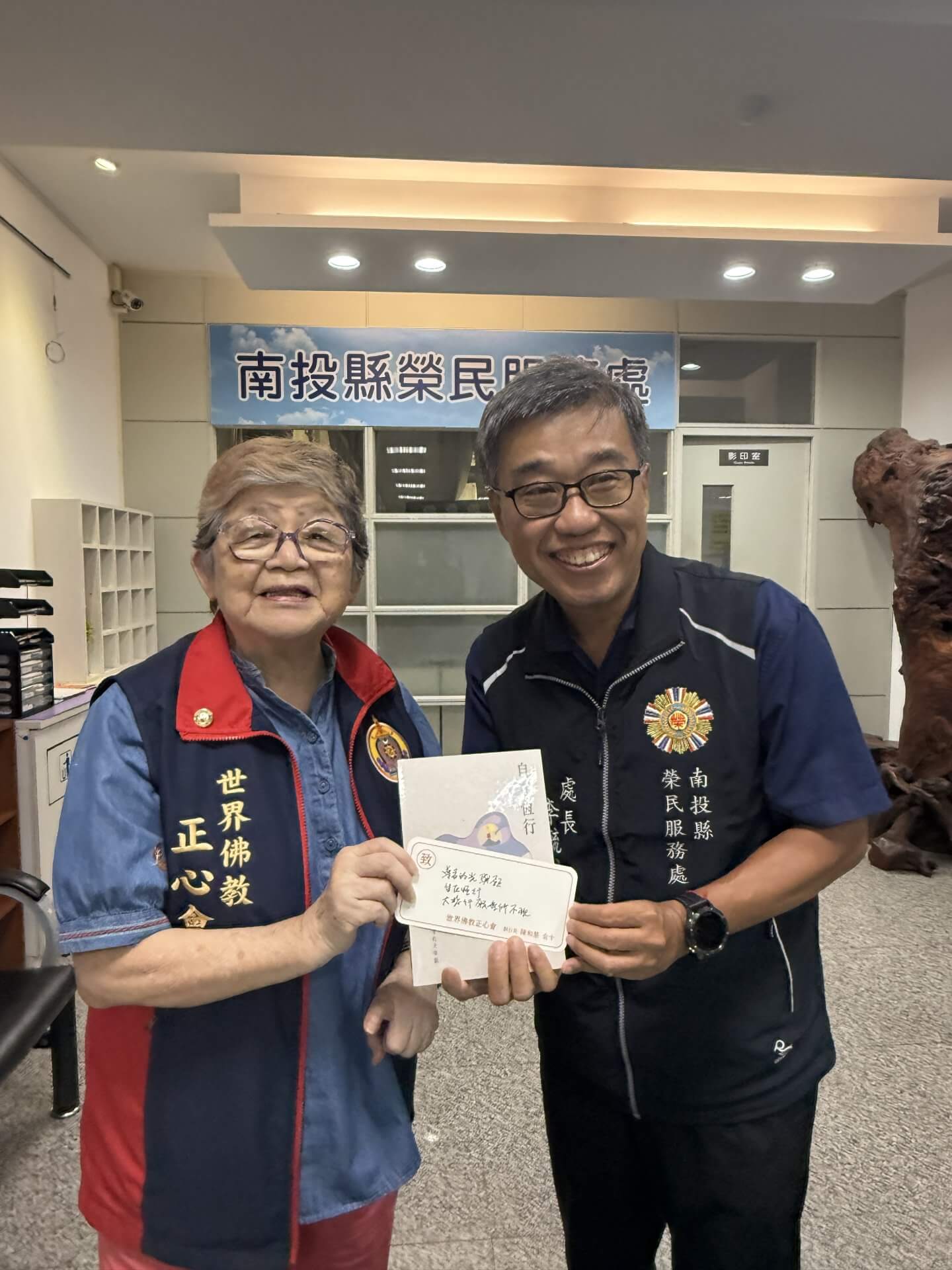 佛教正心會至南投榮服處致贈遺孤慰問金，本會執行長致贈榮服處李毓錫處長上師傳記"自在恆行"