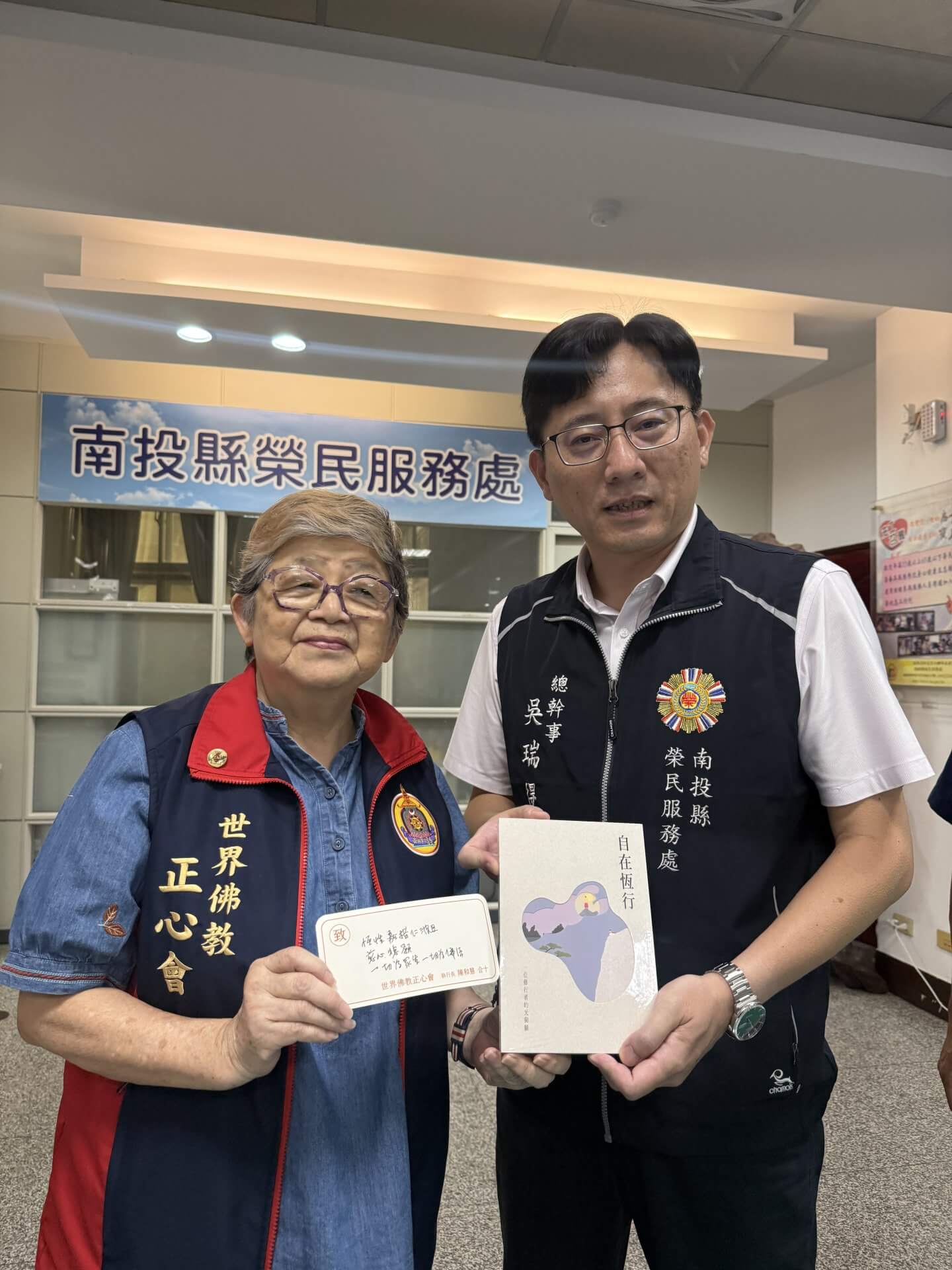 佛教正心會至南投榮服處致贈遺孤慰問金，本會執行長致贈榮服處吳瑞得總幹事上師傳記"自在恆行"